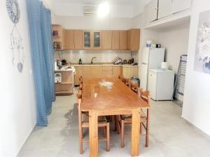 a kitchen with a wooden table and chairs at Marys Home Eretria in Malakóndas