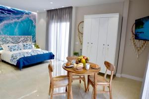 a room with a table and chairs and a bed at La Sirena Playa C in Puerto de la Cruz