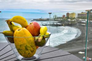 a bowl of fruit on a table with a view of the beach at La Sirena Playa C in Puerto de la Cruz