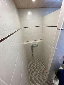 a small bathroom with a shower with a tile floor at Joli studio refait à neuf in Chamrousse
