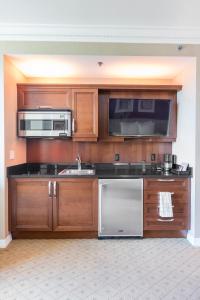 Una cocina con gabinetes de madera y electrodomésticos de acero inoxidable. en MGM Signature Towers by FantasticStay, en Las Vegas