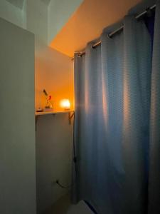 a bathroom with a shower with a blue curtain at Moa Sea Residences Staycation in Manila