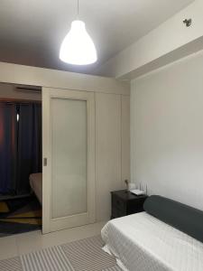 a bedroom with a bed and a light on the ceiling at Moa Sea Residences Staycation in Manila