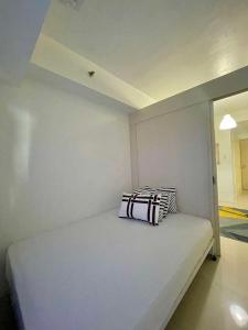 a room with a bed with two pillows on it at Moa Sea Residences Staycation in Manila