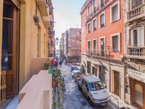 a narrow street with cars parked on the side at Homeboutique in Cagliari