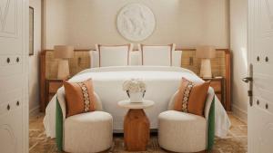 a bedroom with a large white bed with two chairs at Jumeirah Beach Hotel Dubai in Dubai