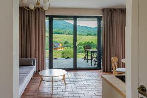a living room with a couch and a table at Biestroska - apartamenty widokowe in Wetlina