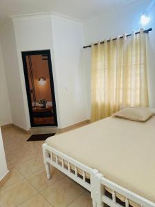a white bed in a room with a window at White House Homestay in Cochin