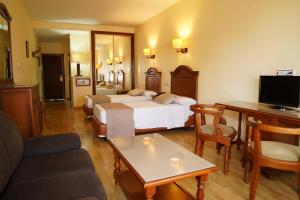 a hotel room with two beds and a couch at Balneario San Nicolas in Alhama de Almería