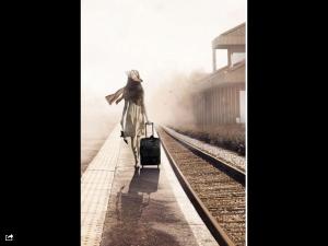 una donna con una valigia che cammina sui binari del treno di Casa Vacanze La Stazione-Centro a Bracciano
