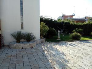 a courtyard with a white building and some plants at B&B VILLA ROSA in Bitritto
