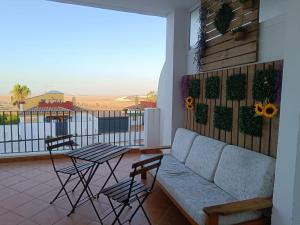 a living room with a couch and a table with chairs at Mirador de los Navegantes in Sanlúcar de Barrameda