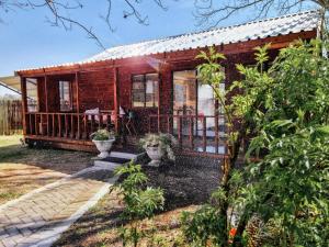 a wooden house with a porch and some plants at Winterton Country Lodge @ Rose Cottage in Winterton