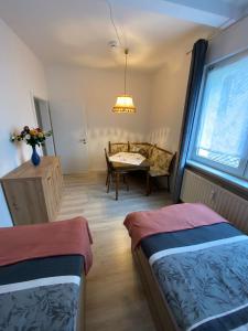 a room with two beds and a table and a couch at Monteurswohnung, Ferienwohnung in Zella-Mehlis