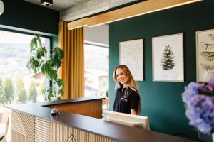 a woman standing at a counter in a office at Śnieżynka in Szczyrk +58 photos