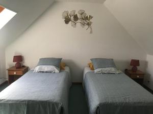 a bedroom with two beds and a heart on the wall at Ar vag in Ploubazlanec