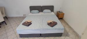 a bedroom with a bed with two towels on it at Budget Friendly in Požega