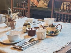 a table with plates and cups and utensils on it at Sand Manor in Sidbury