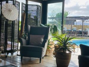 a living room with two chairs and a pool at Kalufa Surf House in El Cuchillo +47 photos