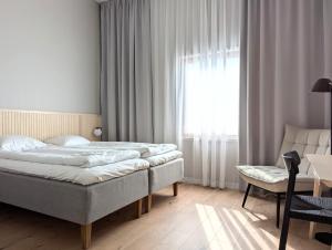 a bedroom with a bed and a chair and a window at Arctic Nest in Kotila