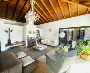 a living room with a couch and a chandelier at Kalufa Surf House in El Cuchillo