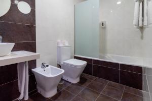 ein Badezimmer mit einem WC, einem Waschbecken und einer Badewanne in der Unterkunft Hotel Doña Luisa in San Luis de Sabinillas + 37 Fotos