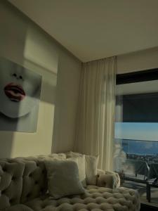 a living room with a couch in front of a window at Primosten Resort Sunhill Deluxe Apartment Laura in Primošten