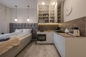 a small bedroom with a bed and a kitchen at Old Town - Bajor Studios - Self Check-in and Parking in Kaunas