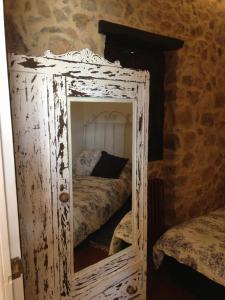 ein alter Spiegel in einem Zimmer mit einem Bett in der Unterkunft La Casita Del Castañar in Béjar