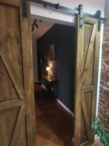 an open barn door in a room with a table at Apartament Comfort Sanok in Sanok