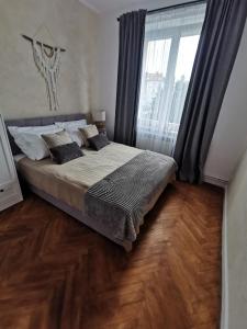 a bedroom with a bed and a large window at Apartament Comfort Sanok in Sanok