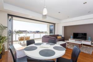 a living room with a white table and chairs at Gallery On High Pool, Port Views & Free Park in Fremantle