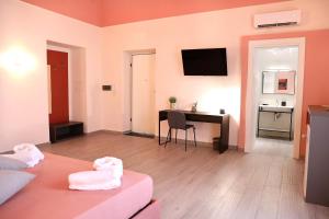 a living room with a bed and a desk with a television at Domus Alma Pompei in Pompei