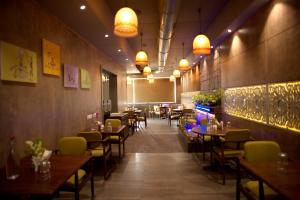 uma sala de jantar com mesas, cadeiras e luzes em Hotel Platinum Inn em Ahmedabad