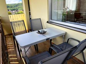 a table and chairs on a balcony with a window at Mitten im Altmühltal - 110 qm in Solnhofen