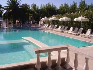 a large swimming pool with chairs and umbrellas at Camping Village Riviera in Numana