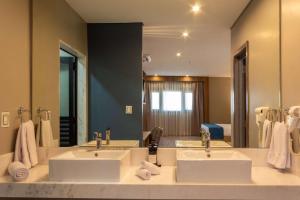 une salle de bain avec deux lavabos et un grand miroir dans l'établissement Tryp by Wyndham Asuncion, à Asuncion