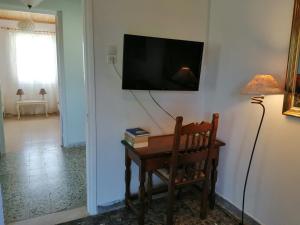 Pokój ze stołem i telewizorem na ścianie w obiekcie Dina's House w mieście Agía Thékli