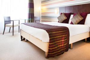 a bedroom with a large bed and a table and chair at Lanes Hotel in Yeovil