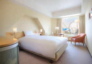 a hotel room with a large bed and a roller coaster at Tokyo Dome Hotel in Tokyo