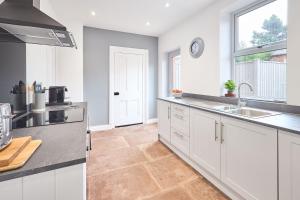 a kitchen with white cabinets and a sink and a window at Host & Stay - The Beeches in Hayton