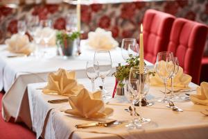 un conjunto de mesas con copas de vino y servilletas en Hotel Alpenblume, en Damüls
