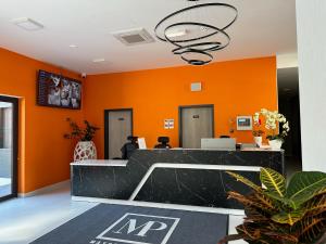 an office with orange walls and a reception desk at Mayor Pension in Komárno