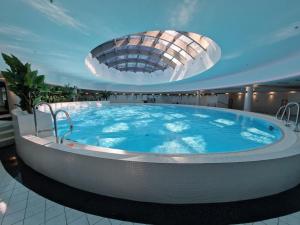 una grande vasca idromassaggio in un edificio con soffitto di Apartly - Hanza Tower apartament City View, parking, pool, sauna a Stettino