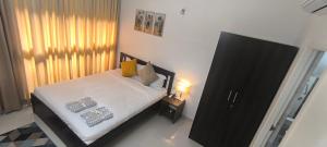 a bedroom with a bed with white sheets and yellow pillows at Goodstay Elegant Ocean-Themed -207 in Dabolim +55 photos