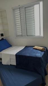 two beds in a room with a window at Descubra seu novo espaço preferido em Americana-SP in Americana