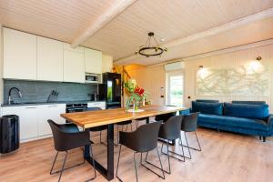 a kitchen with a dining table and a blue couch at Namelis ant ežero kranto "Elingas" in Tytuvėnai +48 photos