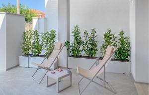 2 Stühle und ein Tisch auf einem Balkon mit Pflanzen in der Unterkunft Cozy Apartment In Marina Di Modica in Marina di Modica + 8 Fotos