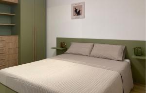 ein Bett in einem Schlafzimmer mit Grün und Weiß in der Unterkunft Cozy Apartment In Marina Di Modica in Marina di Modica