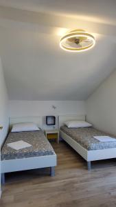 two beds in a room with a ceiling at Villa Vitanese in Tkon